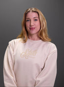 Woman wearing a beige sweatshirt with text on a gray background