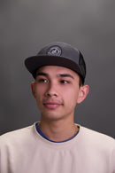 person wearing a grey trucker hat front view